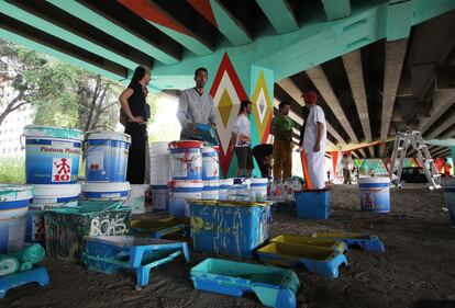 Decenas de residentes se han puesto este fin de semana el mono de trabajo y se han manchado las manos para crear un mural colectivo en los bajos del puente de la carretera de Andalucía (A-4), uno de los accesos al distrito. “Así sí que dan ganas de entrar”, asegura Isaac Vilaña, uno de los participantes.