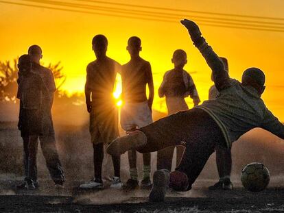 Diversos joves juguen a futbol.