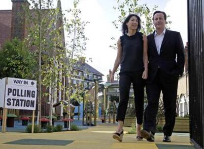 El líder conservador británico, David Cameron, y su esposa, Samantha, salen de un colegio electoral.