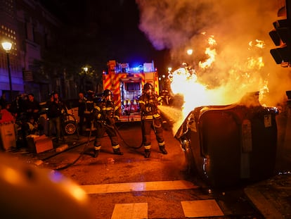 Bomberos apagan un contender ardiendo tras la concentración contra la amnistía convocada en las inmediaciones de la sede del PSOE en la madrileña calle de Ferraz, este jueves, que volvió a acabar con incidentes y cargas policiales.