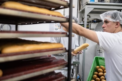 El menor panadero, al fondo, trabaja durante la madrugada en la panadería del Centro de Menores Teresa de Calcuta.