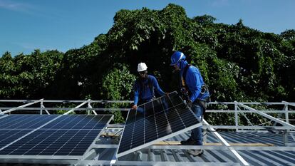 Trabajadores instalan paneles solares en la favela Chapeu Mangueira, en Río de Janeiro, Brasil, en marzo de 2023.