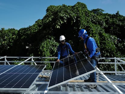 Trabajadores instalan paneles solares en la favela Chapeu Mangueira, en Río de Janeiro, Brasil, en marzo de 2023.