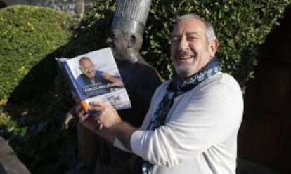 Karlos Arguiñano sostiene su último libro de recetas junto a la estatua erigida en su nombre.