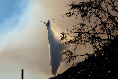 Un helicóptero lanza agua para contener el incendio de Palisades, en Los Ángeles, el 11 de enero.