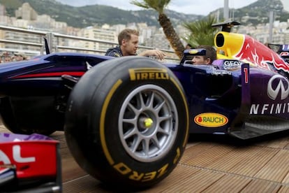  Vettel habla con Ogier en Montecarlo enfrente de un monoplaza de Red Bull.