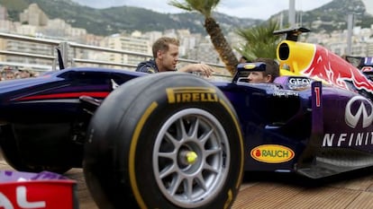  Vettel habla con Ogier en Montecarlo enfrente de un monoplaza de Red Bull.