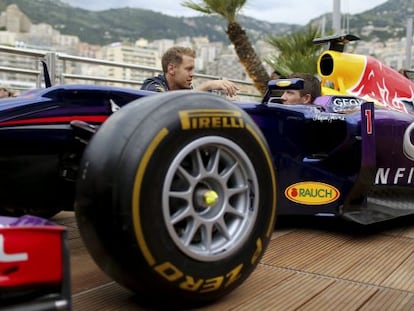  Vettel habla con Ogier en Montecarlo enfrente de un monoplaza de Red Bull.