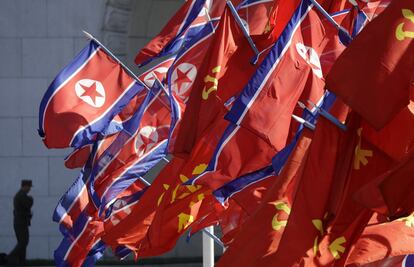 Banderas norcoreanas ondean en al entrada de la nueva zona residencial.