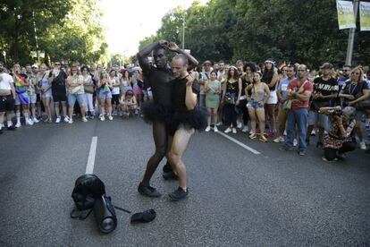 Dos participantes en el desfile del día del orgullo en Madrid, bailan en un momento del recorrido.
