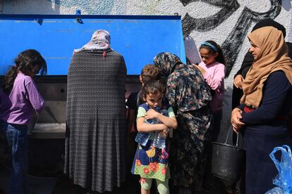 Mujeres palestinas recogen agua en en patio del colegio de la UNRWA, este viernes en Jan Yunis.