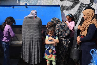 Mujeres palestinas recogen agua en en patio del colegio de la UNRWA, este viernes en Jan Yunis.