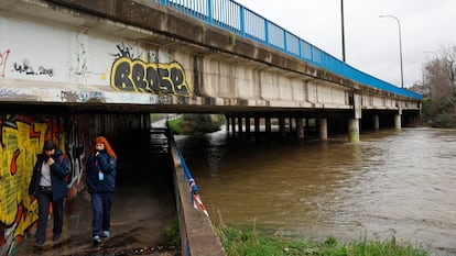 Dos mujeres cruzan por debajo del puente de la M-30 a su paso por San Pol de Mar, este viernes.