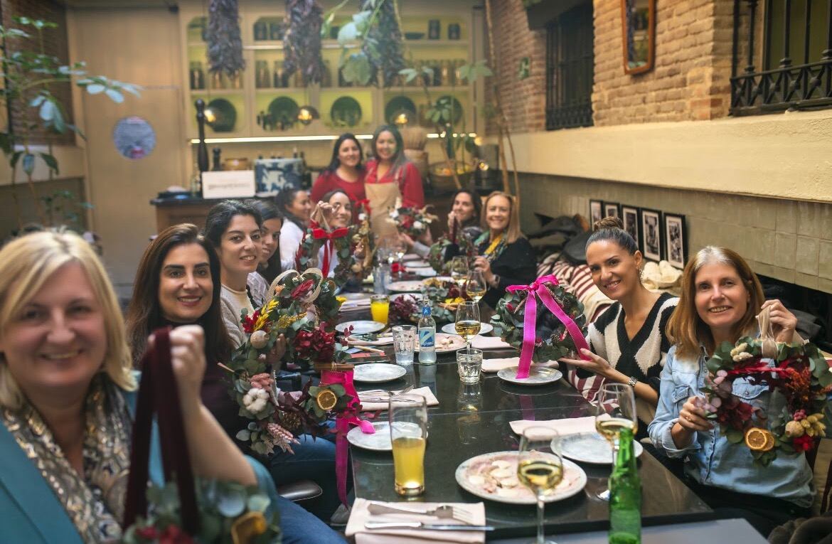 Un grupo de mujeres muestran los arreglos florales que hicieron en el taller de Misspitimini, en Madrid.
