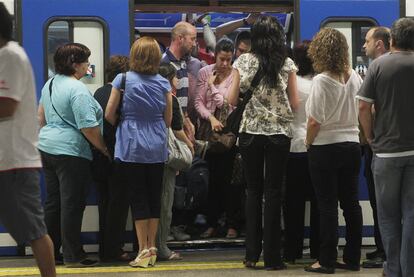 Viajeros intentan salir y entrar en uno de los vagones de la red de Metro de Madrid.