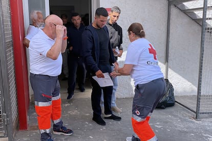Miembros de Cruz Roja atienden a varios de los nueve inmigrantes de origen marroquí, entre ellos un menor, que habían llegado este domingo a la playa del Sotillo en Gualchos, Castell de Ferro (Granada).