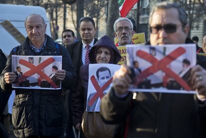 Migrantes sirios e iraníes levantan fotografías del presidente sirio Bashar al-Assad y el líder Ayatollah Ali Khamenei, durante una protesta contra la Guerra Siria frente a la embajada iraní de París (Francia), el 17 de diciembre de 2016.