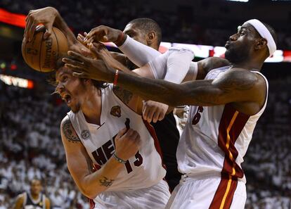 El jugador de los Spurs Tim Duncan, ante Mike Miller y LeBron James, de los Heat.