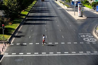 Un hombre cruza corriendo el paseo de la Castellana de Madrid, el puente de agosto de 2023. 