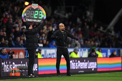 Los tableros enmarcados con los colores LGBT han dicho presente en todos los estadios de la Premier. En la foto, el entrenador del Manchester City, Pep Guardiola, da instrucciones a un costado del cuarto árbitro mientras éste eleva el cartel.