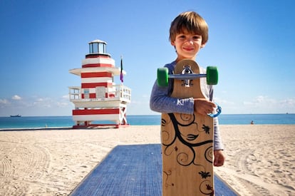 Un niño en la playa de Miami Beach, con la torre de vigilancia Jetty al fondo.