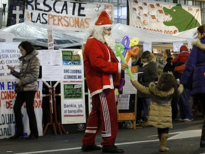 Papá Noel reparte globos frente a los acampados de Bankia.