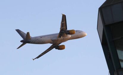 Un A320 de Vueling sobrevuela la torre de control del aeropuerto de Barcelona-El Prat.