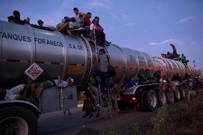Un grupo de migrantes sube a bordo de un camión cisterna con la esperanza de que el conductor les lleve, en Tapanatepec (México).