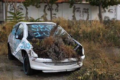 An abandoned car among other works by street artist Vhils in one of Braço de Prata's courtyards.