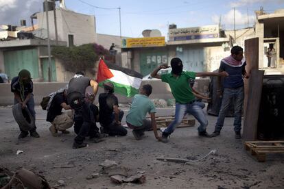 Palestinos lanzan piedras contra soldados israelíes en el puesto de control de Kalandia, entre Jerusalén y Ramala.