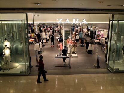 Una empleada con mascarilla en la entrada de una tienda Zara en Kuala Lumpur (Malasia), en mayo.