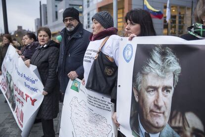 Manifestantes ante el Tribunal de La Haya con pancartas donde se ve a Radovan Karadzic, expolítico serbio de Bosnia y criminal de guerra convicto, mientras esperan el veredicto del juicio al militar serbobosnio Ratko Mladic, este miércoles, 22 de noviembre de 2017. El general Mladic ha sido acusado de genocidio por la masacre de Srebrenica y por promover la eliminación de los bosniocroatas y los bosniacos durante la guerra de Bosnia y Herzegovina (1992-1995).