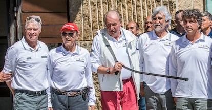 El rey emérito ha salido de la casa de Pedro Campos, su anfitrión (en la imagen, con gorra roja), sobre las 12.20. Diez minutos después ha llegado al Real Club Náutico de Sanxenxo, donde están los pantalanes de embarque, en medio de una enorme expectación.