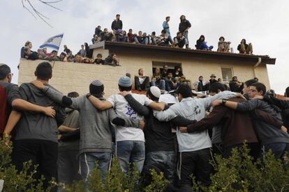 Un grupo de jóvenes israelíes partidarios de los asentamientos se reúnen alrededor y sobre el tejado de una casa pendiente de ser desalojada y demolida, en el asentamiento de Ofra (Cisjordania). En dicho emplazamiento, el tribunal supremo ha ordenado la demolición de nueve viviendas construidas en territorio privado palestino.