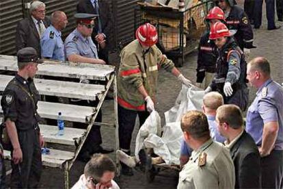 Equipos de rescate recogen el cadáver de un hombre muerto en la explosión en un mercado de Moscú.