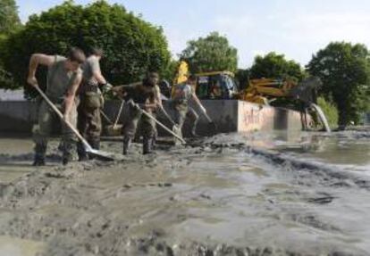 Varios soldados limpian una calle llena de barro por las recientes  inundaciones causadas por  el desbordamiento del Danubio a su paso por la localidad de Melk, Austria. EFE/Archivo