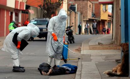 Personal sanitario arroja desinfectante en un cadáver encontrado en la calle en Cochabamba, Bolivia, el 25 de julio de 2020.