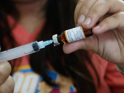 Una enfermera prepara la dosis para administrar una vacuna.