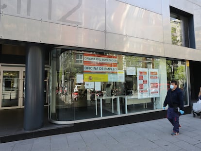 Un hombre con mascarilla pasa frente a una oficina de empleo en Madrid.