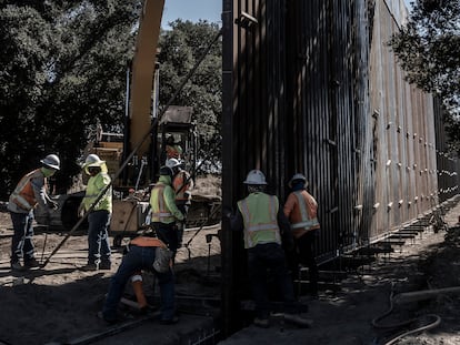 Workers erecting the new border wall in the desert of Baja California.