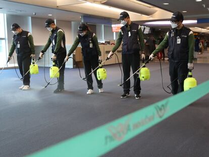 Operários desinfetam a zona alfandegária do aeroporto internacional de Incheon (Coreia do Sul).