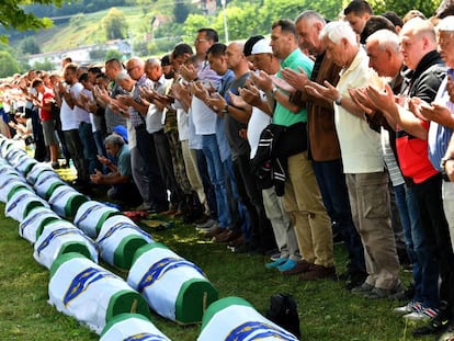 Musulmanes bosnios rezan frente a los cuerpos de 33 hombres recientemente identificados como víctimas de Srebrenica, el pasado 11 de julio de 2019.