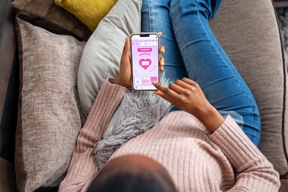 Una joven observa una aplicación de menstruación. 