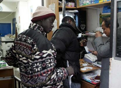 Unos inmigrantes hacen cola en un locutorio madrileño.