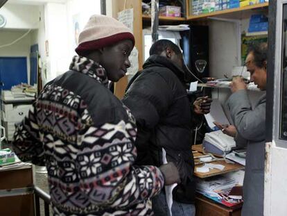 Unos inmigrantes hacen cola en un locutorio madrileño.