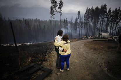 Una pareja se abraza mientras ven salir humo de un área devastada por el fuego en Las Golondrinas, en la provincia de Chubut, en el sur de Argentina, el día de hoy.