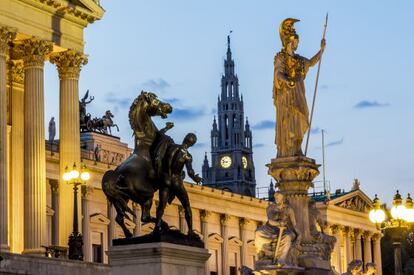 El edificio del Parlamento, con una estatua de Palas Atenea en primer plano y la torre del ayuntamiento al fondo.