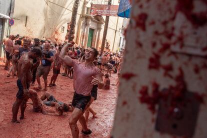 Varias personas se lanzan tomates durante la fiesta de La Tomatina, este miércoles, en Buñol.