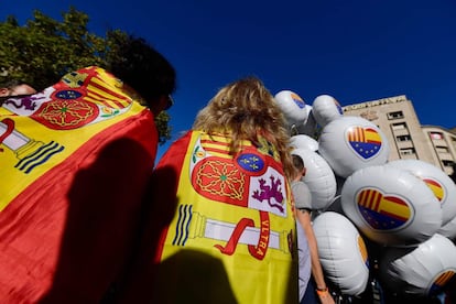 Duas mulheres envoltas em bandeiras da Espanha em Barcelona.