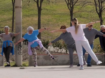 Una monitora guía a varias personas mayores en el barrio madrileño de Vallecas el 30 de marzo en el parque del Tío Pío.